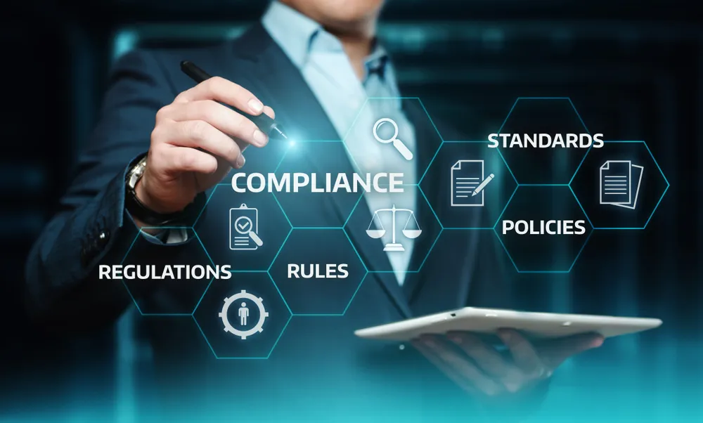 Ein Mann, der ein iPad benutzt, umgeben von Begriffen wie „Compliance“, „Richtlinien“ und „Regeln“