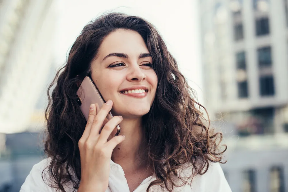 Frau, die in einer Stadt mit dem Handy telefoniert