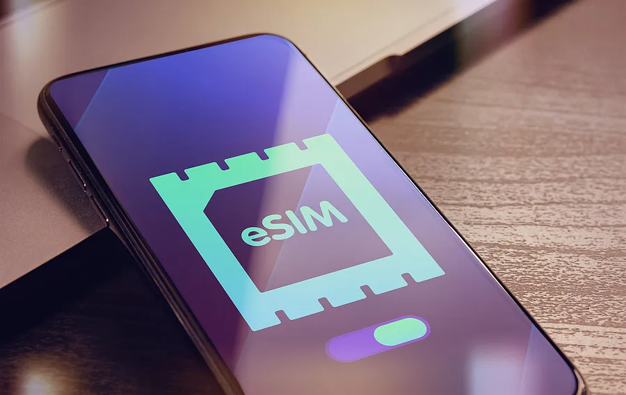Smartphone auf dem Schreibtisch, auf dem das eSIM-Logo zu sehen ist