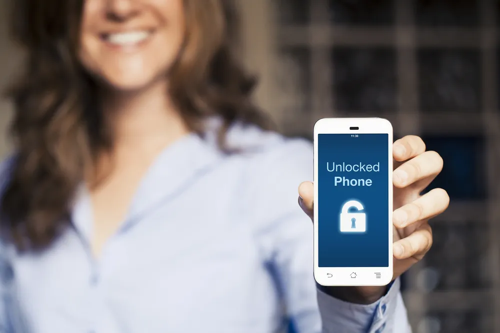glücklicher Mensch, der ein entsperrtes iPhone in der Hand hält