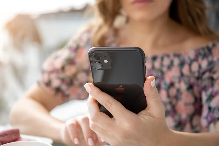 Frau, die ein iPhone 11 in der Hand hält