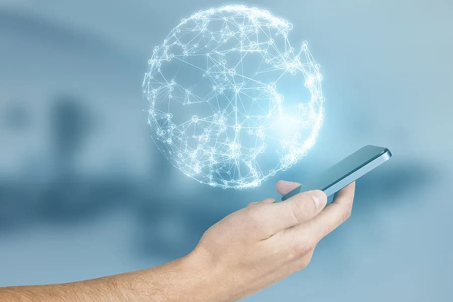 Hand, die ein iPhone hält, über dem ein Planet zu sehen ist