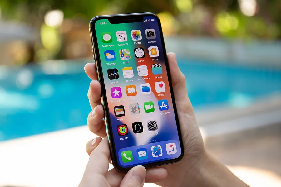 Eine Hand, die das iPhone im Freien hält, um zu zeigen, was „True Tone“ auf dem iPhone ist.