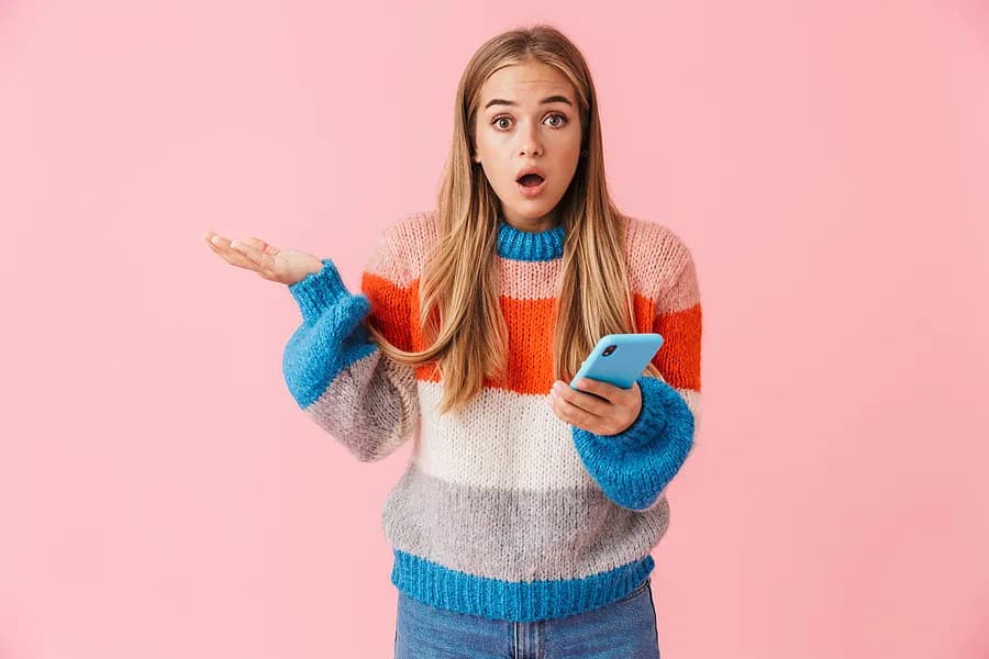 Junge Frau, die ein blaues Handy in der Hand hält und so aussieht, als würde sie eine Frage stellen.