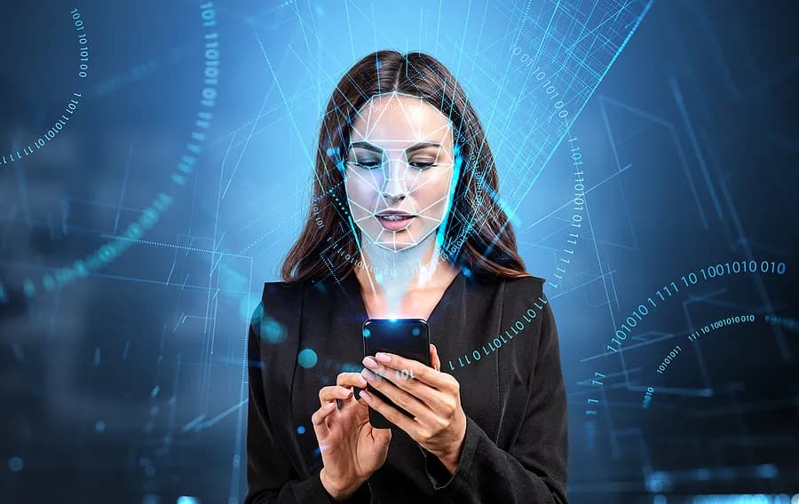 Eine Frau, die ihr Handy vor einem blauen Hintergrund in der Hand hält.