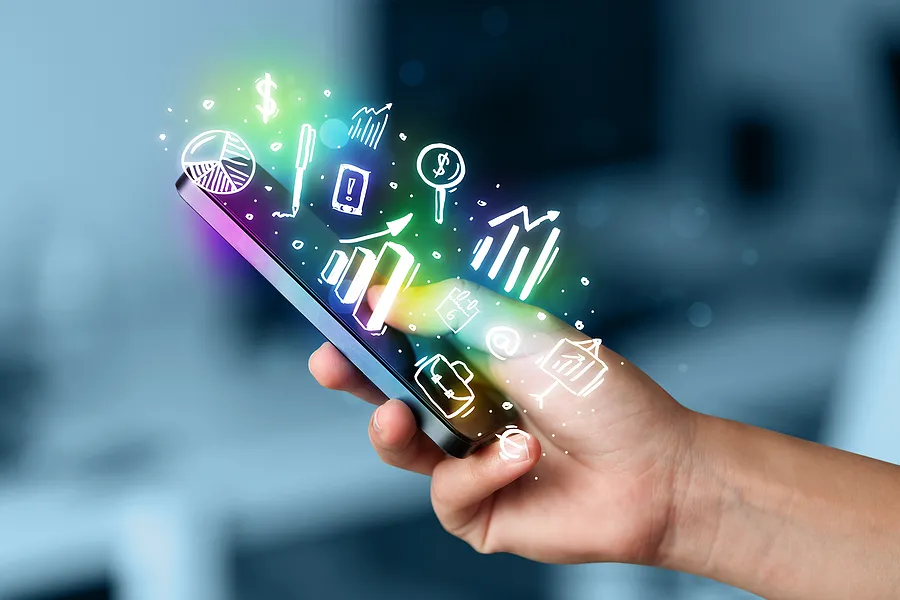 Eine Hand, die ein Handy hält, über dem Symbole zu sehen sind.