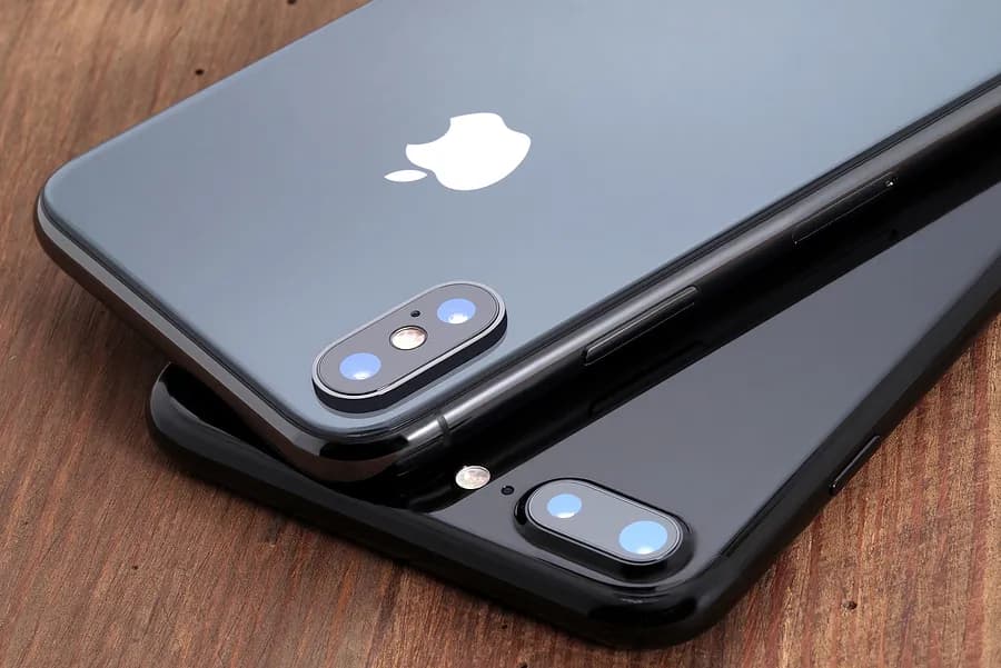 Zwei graue Apple-iPhones, die mit der Vorderseite nach unten liegen.