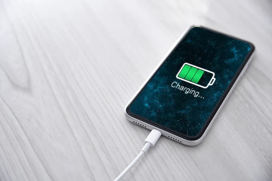 Das Handy ist an das Ladegerät angeschlossen.
